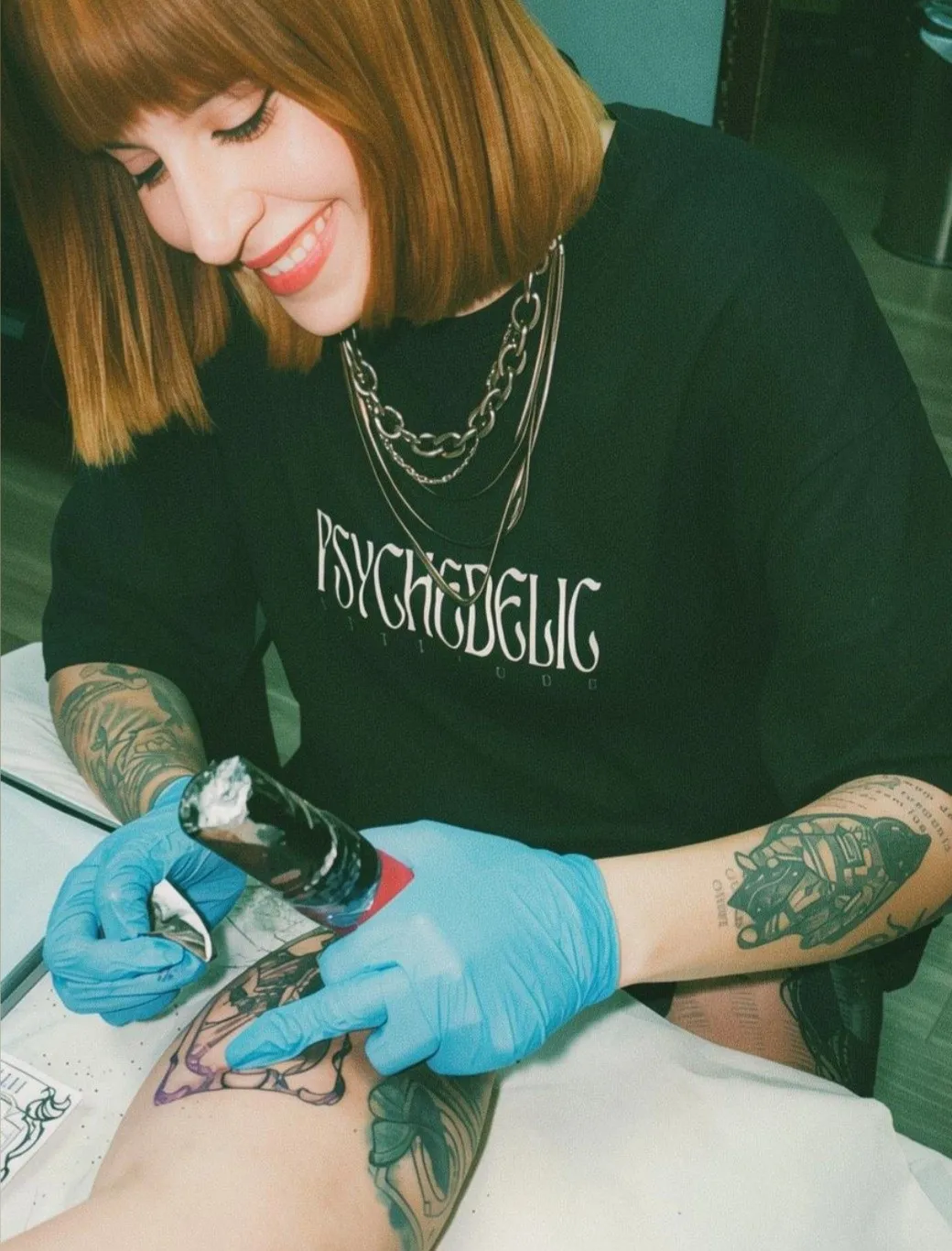 Clara Nasc tatuando uma cliente em seu estúdio em Belo Horizonte
