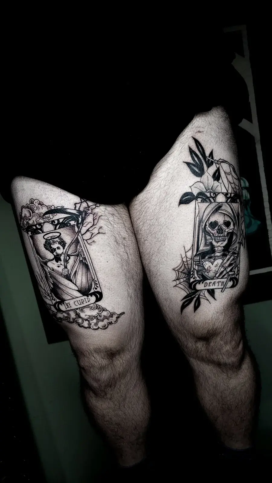Tatuagem blackwork com as cartas de tarô The Cupid e Death, uma em cada coxa