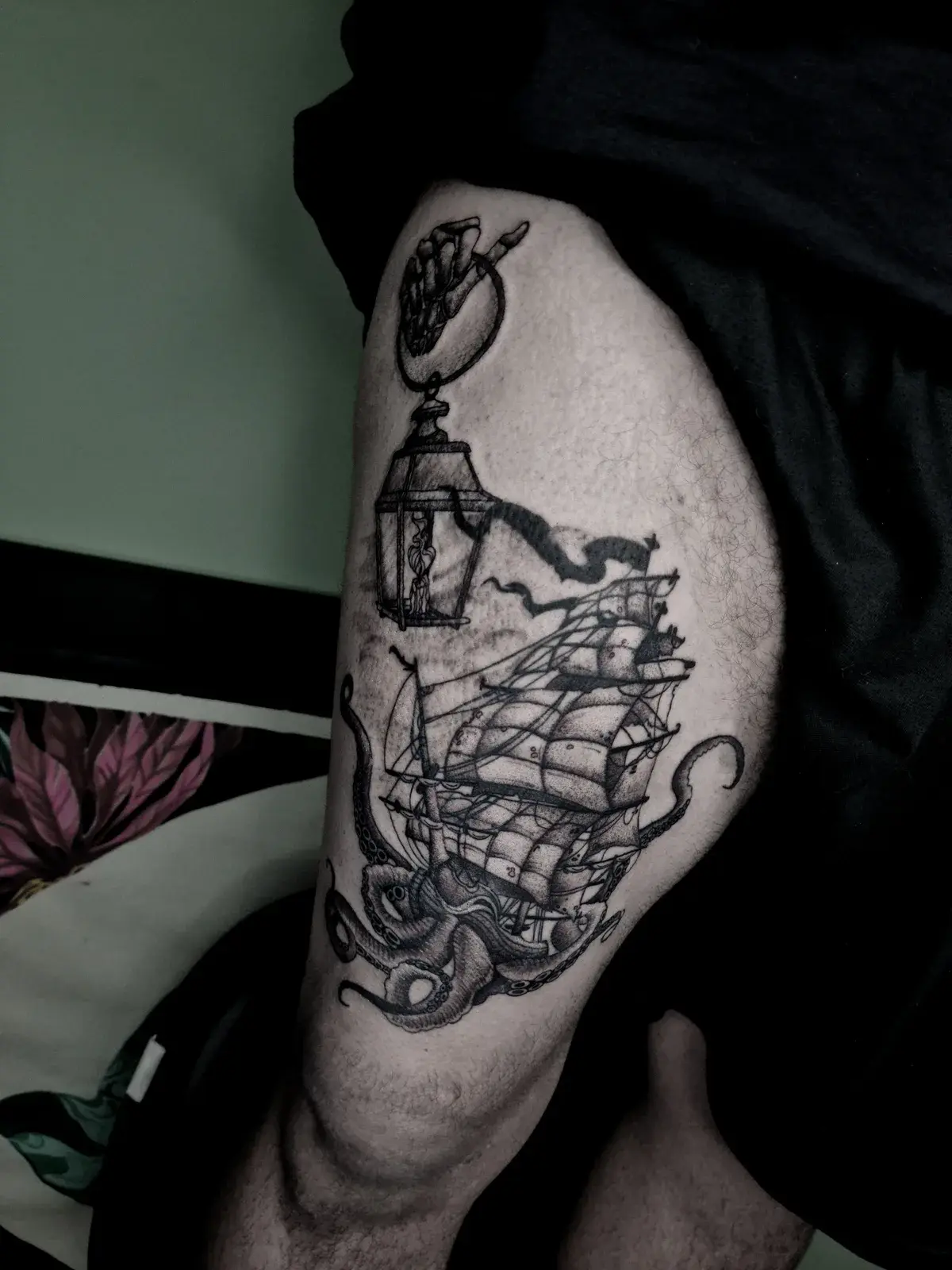 Tatuagem blackwork de navio, lanterna e polvo na coxa