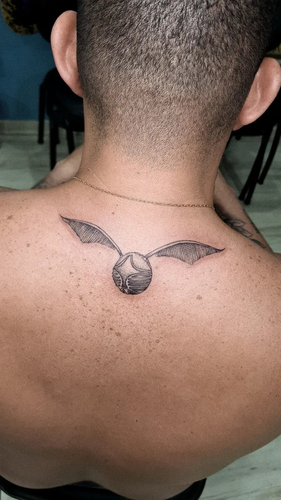 Tatuagem blackwork do pomo de ouro, de Harry Potter, em pontilhismo na nuca
