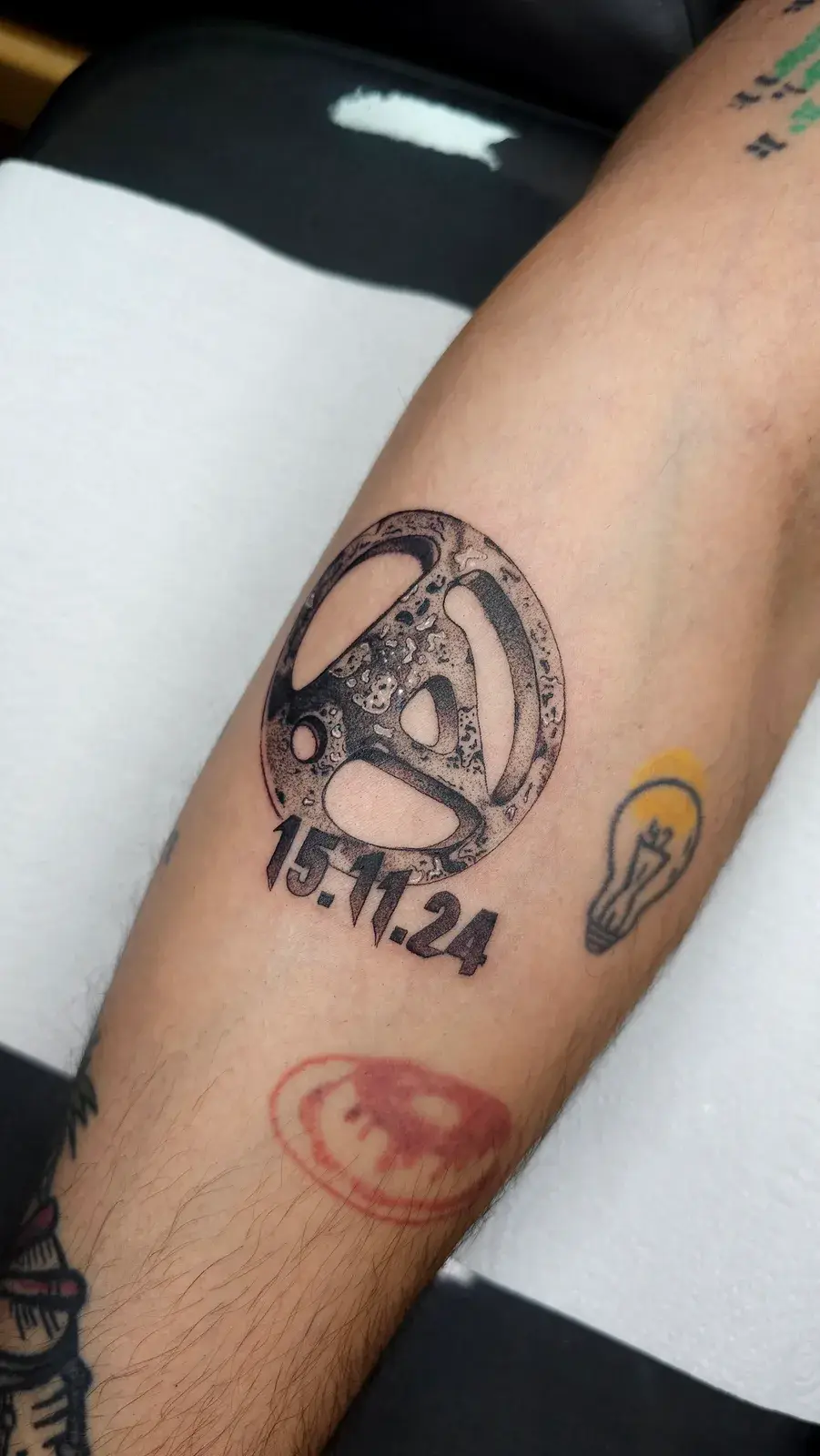 Tatuagem blackwork do símbolo do Linkin Park em pontilhismo na panturrilha, vista de perto