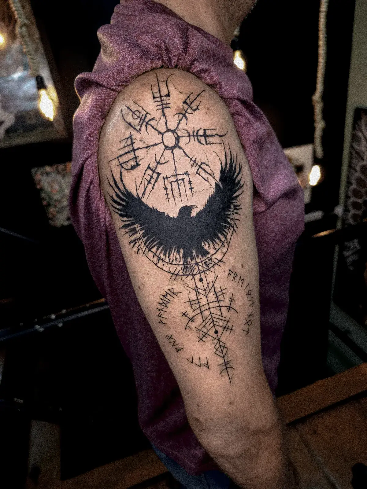 Tatuagem blackwork de bússola viking vegvisir com corvo em preto sólido no ombro