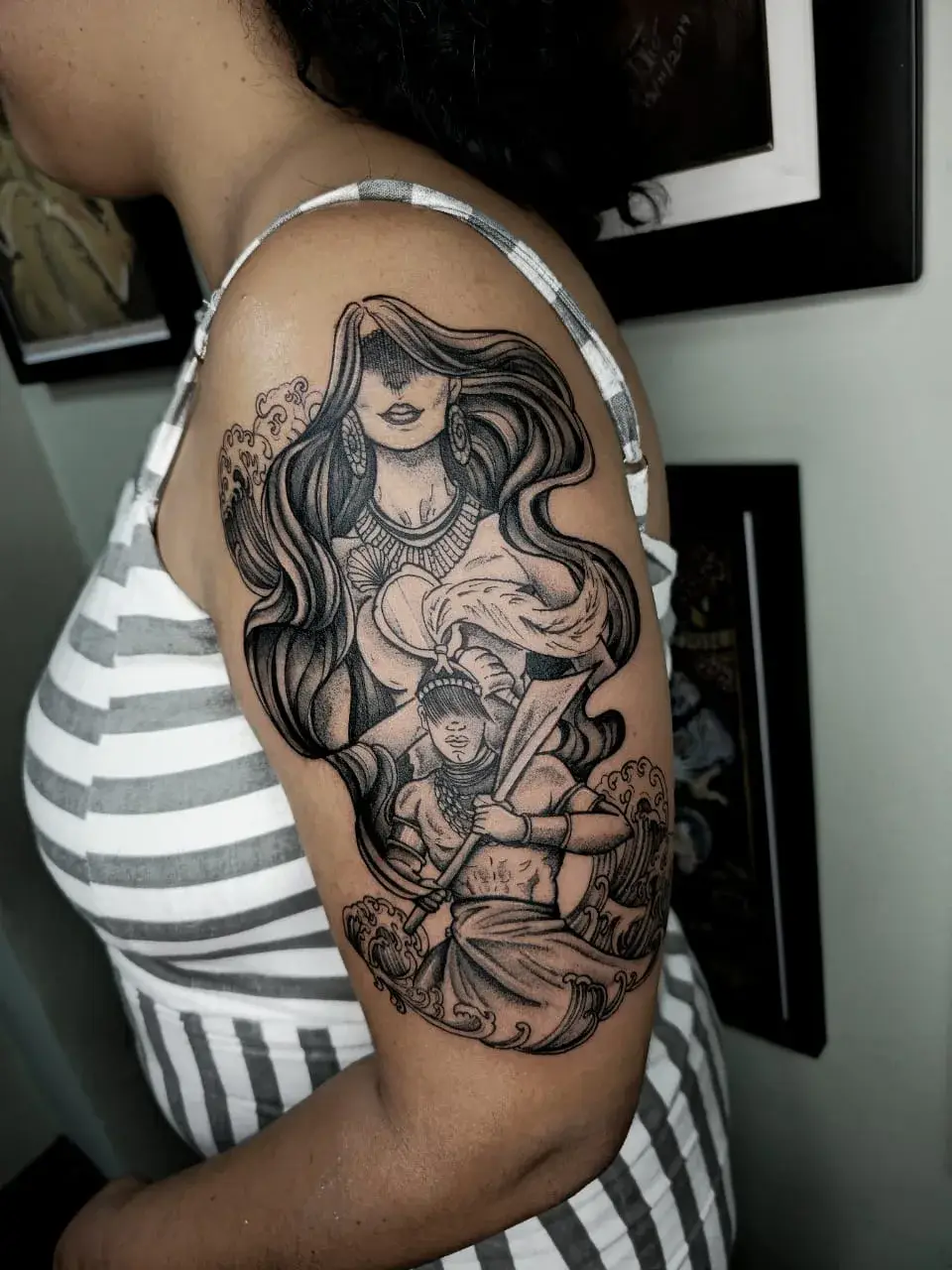 Tatuagem blackwork de Yemanjá e Ogum em braço fechado, com traço ornamental