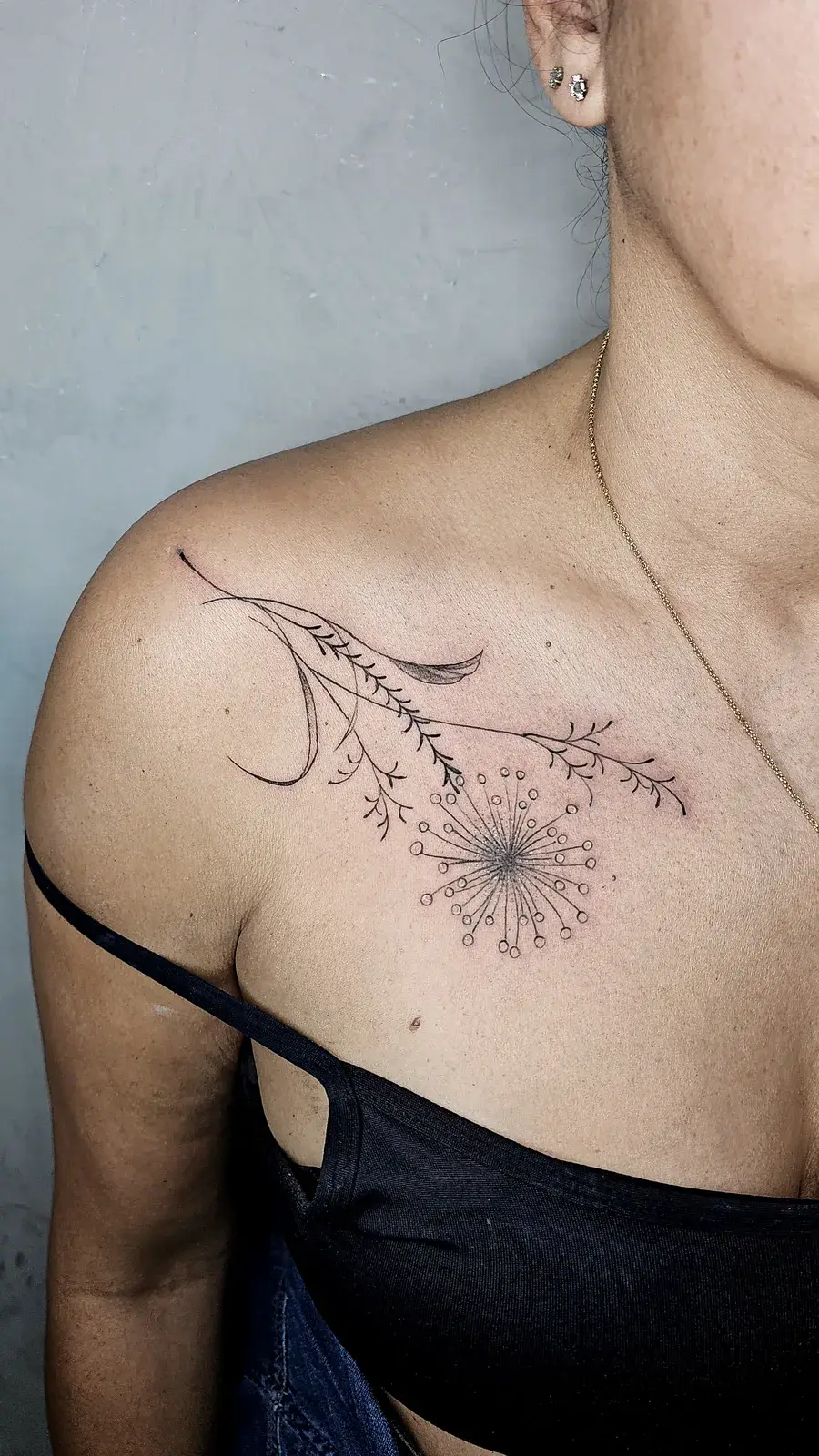 Tatuagem botânica de sempre-viva em traço fino sobre a clavícula