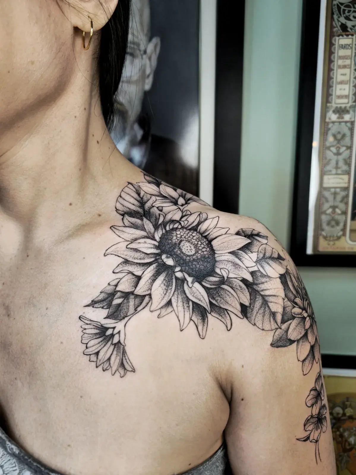 Cobertura de tatuagem antiga com girassol em pontilhismo no ombro e clavícula