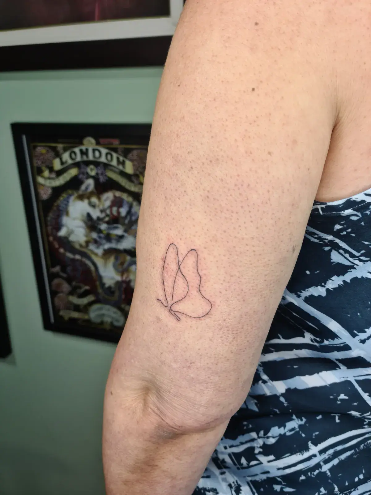Tatuagem fine line de borboleta em linha contínua no braço