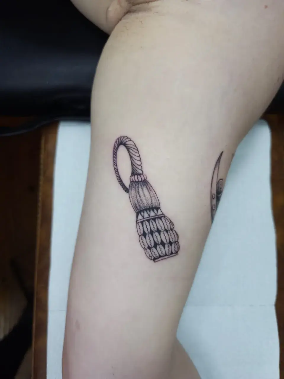 Tatuagem fine line de chocalho em traço minimalista e pontilhismo, no braço