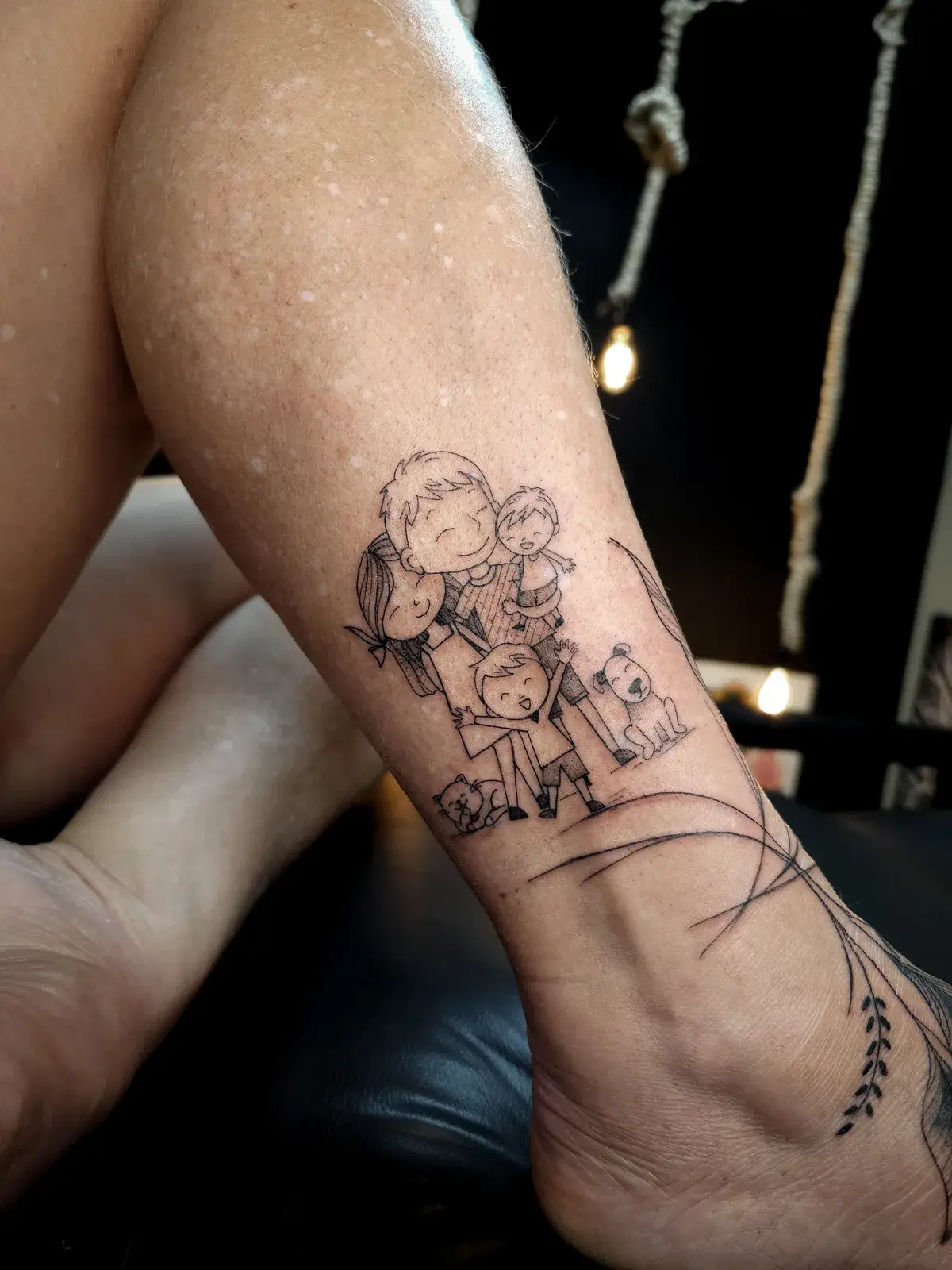 Tatuagem fine line de família ilustrada com cachorros, da panturrilha ao tornozelo