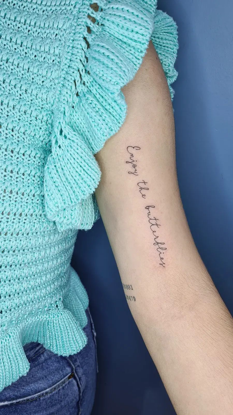 Tatuagem fine line com o lettering Enjoy the butterflies no braço