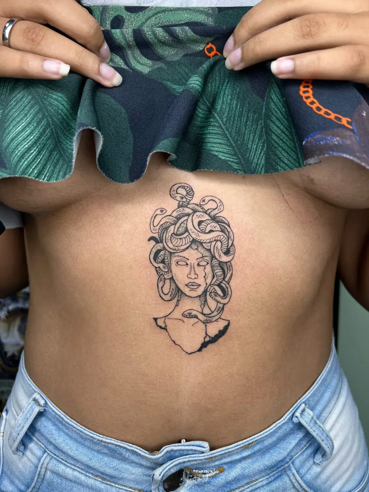 Tatuagem fine line de Medusa com serpentes no abdômen