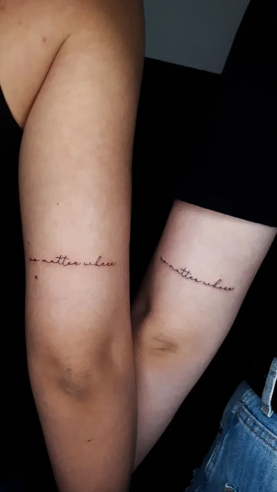 Tatuagem de irmãs em fine line, com lettering em traço fino no braço de duas pessoas