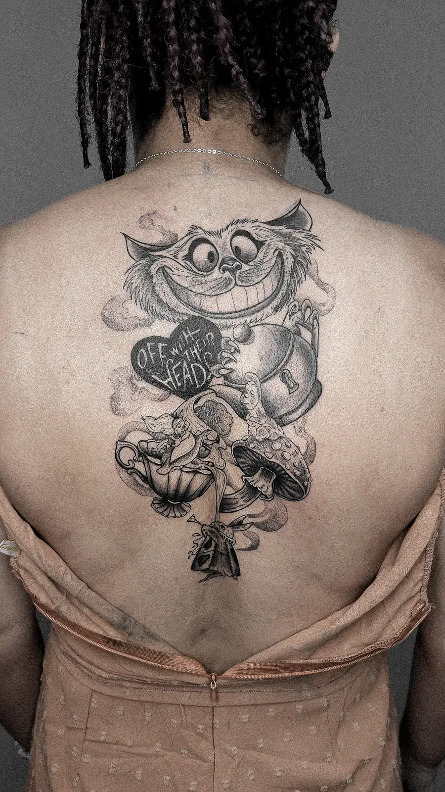 Tatuagem geek de Alice no País das Maravilhas com o Gato de Cheshire e xícaras nas costas