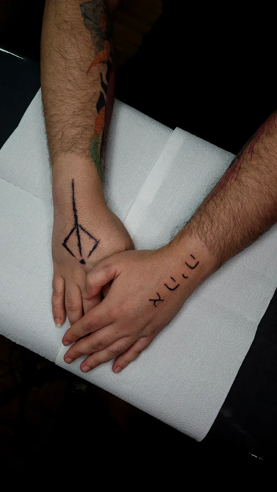Tatuagem geek de Berserk com a marca em preto sólido nas mãos de duas pessoas