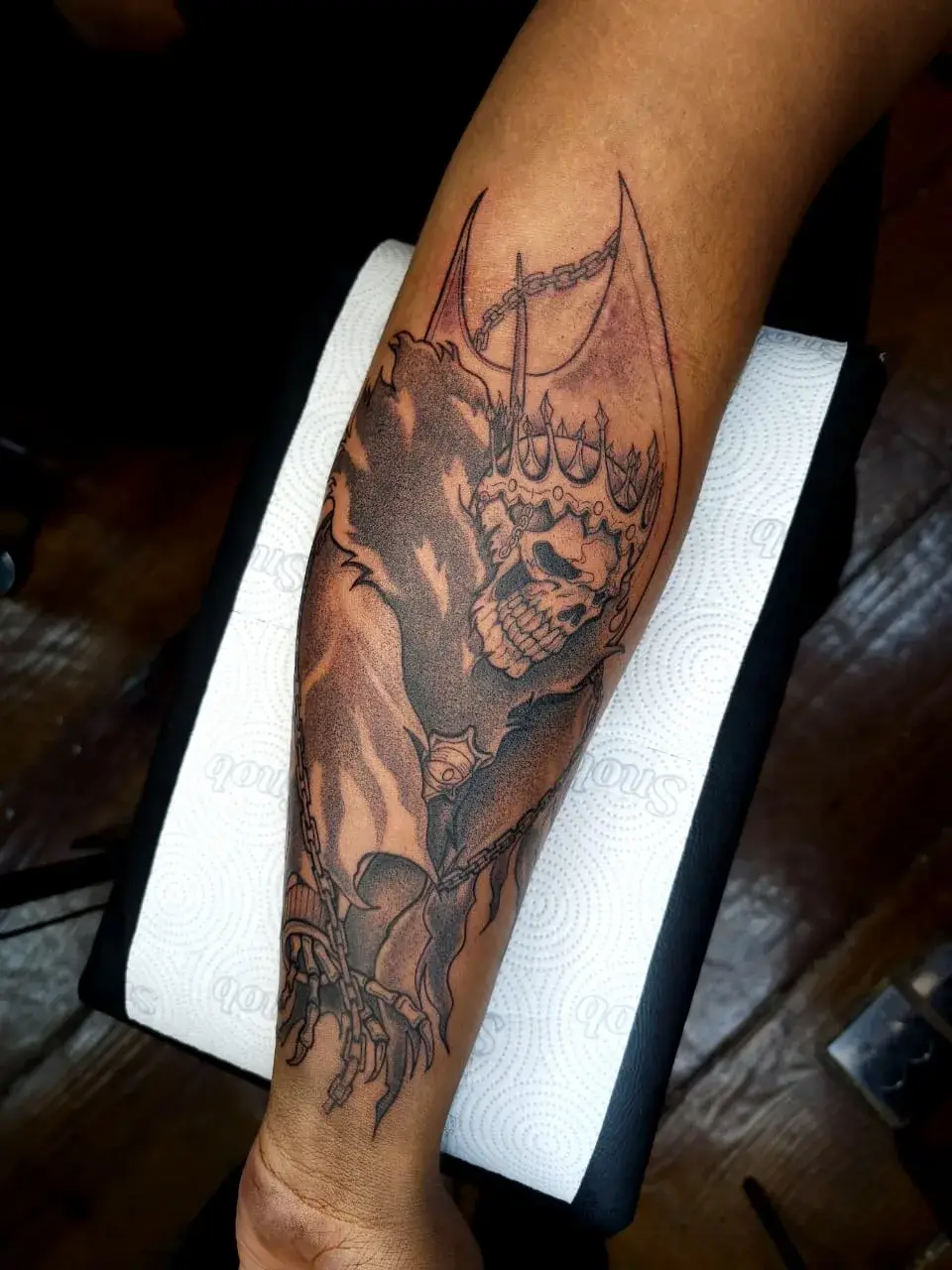 Tatuagem geek do Baraggan, de Bleach, com caveira, asas e correntes no antebraço