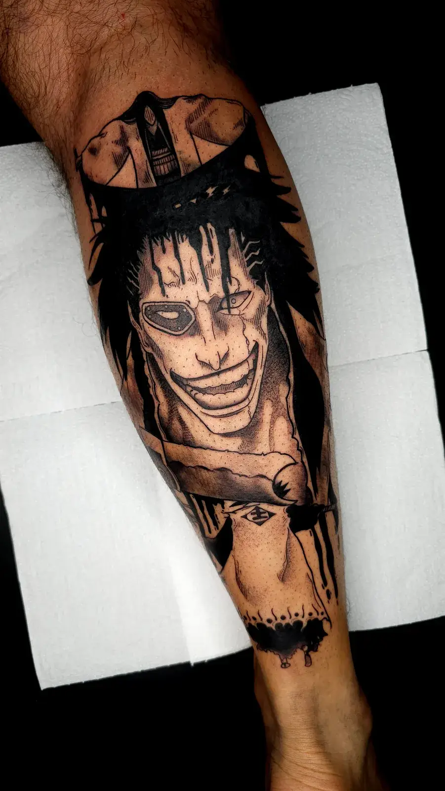 Tatuagem geek de Zaraki Kenpachi, de Bleach, em preto e cinza na panturrilha