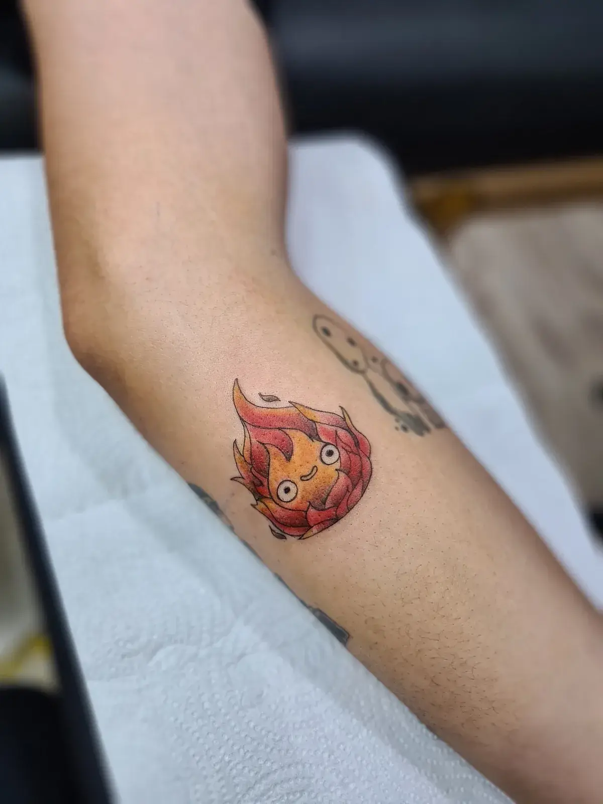 Tatuagem geek do Calcifer, de O Castelo Animado, em cores no antebraço