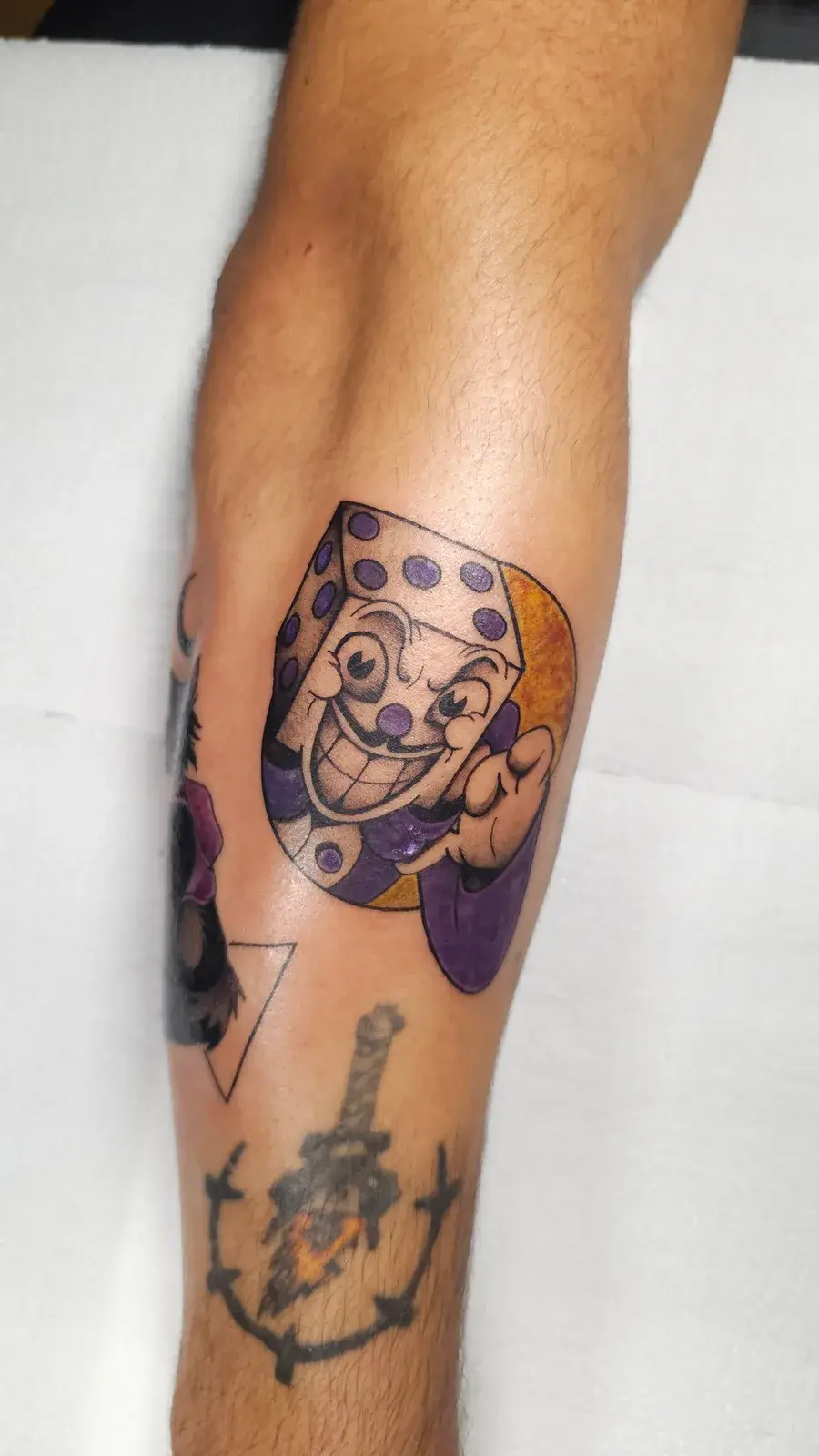 Tatuagem geek do King Dice, de Cuphead, colorido na panturrilha