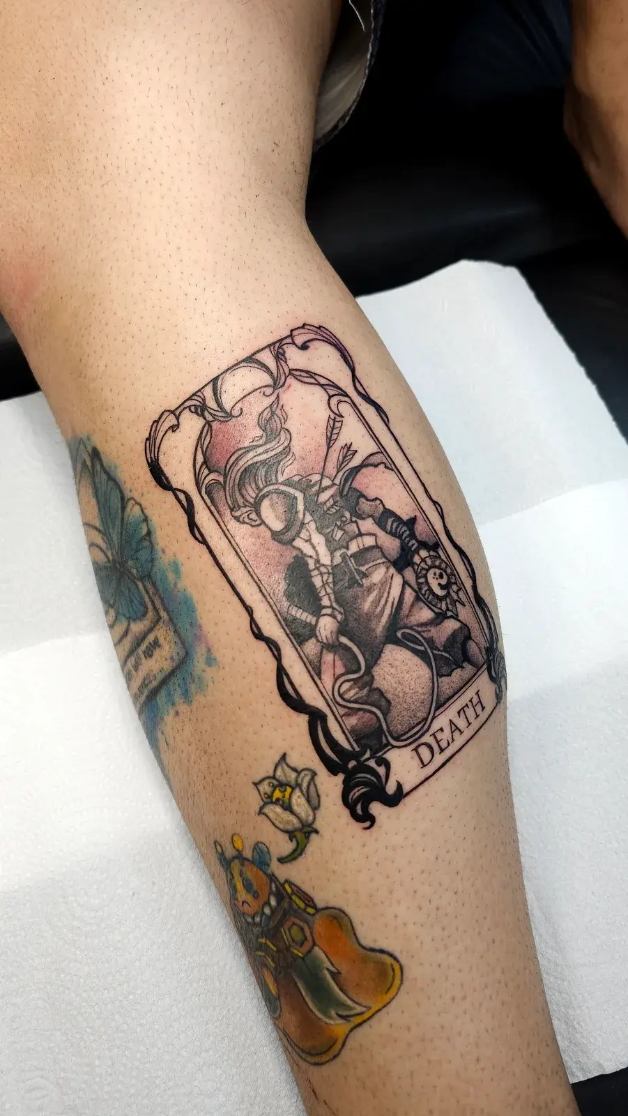 Tatuagem geek de Dead Cells em carta ilustrada, colorida na panturrilha