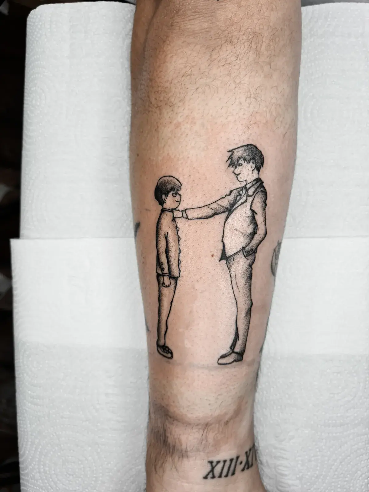 Tatuagem geek de Mob Psycho com dois personagens em traço fino na panturrilha