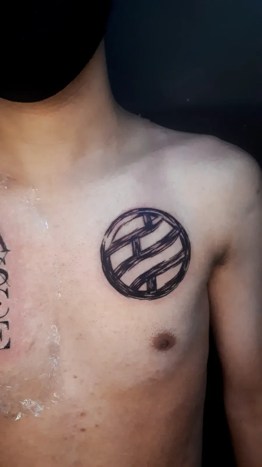 Tatuagem geek de Naruto com o símbolo do clã Nara em preto sólido no peito