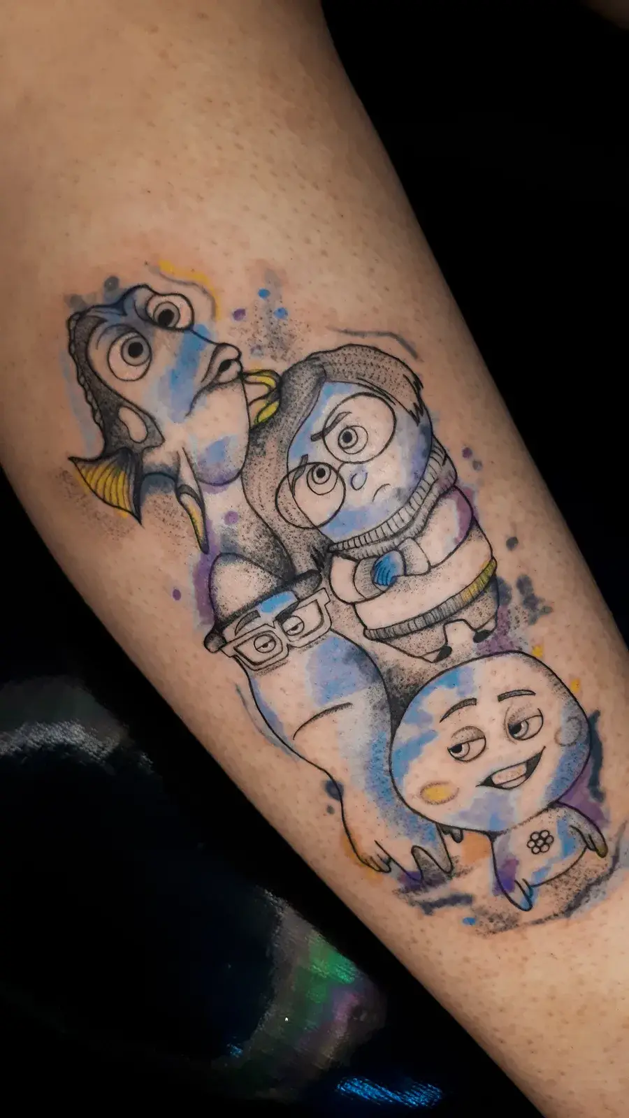 Tatuagem geek com personagens azuis de cinema em aquarela colorida na perna