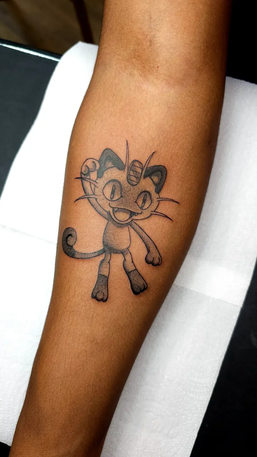 Tatuagem geek de Pokémon com o Meowth em pontilhismo no antebraço