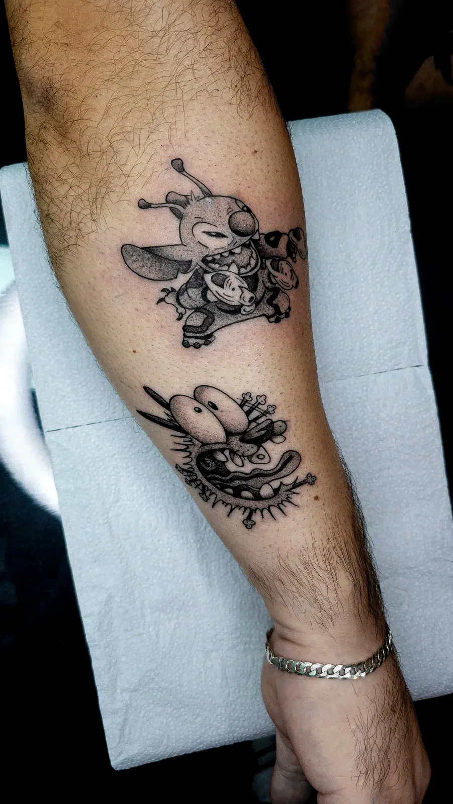 Tatuagem geek do Stitch e do Coragem, o Cão Covarde, em pontilhismo no antebraço