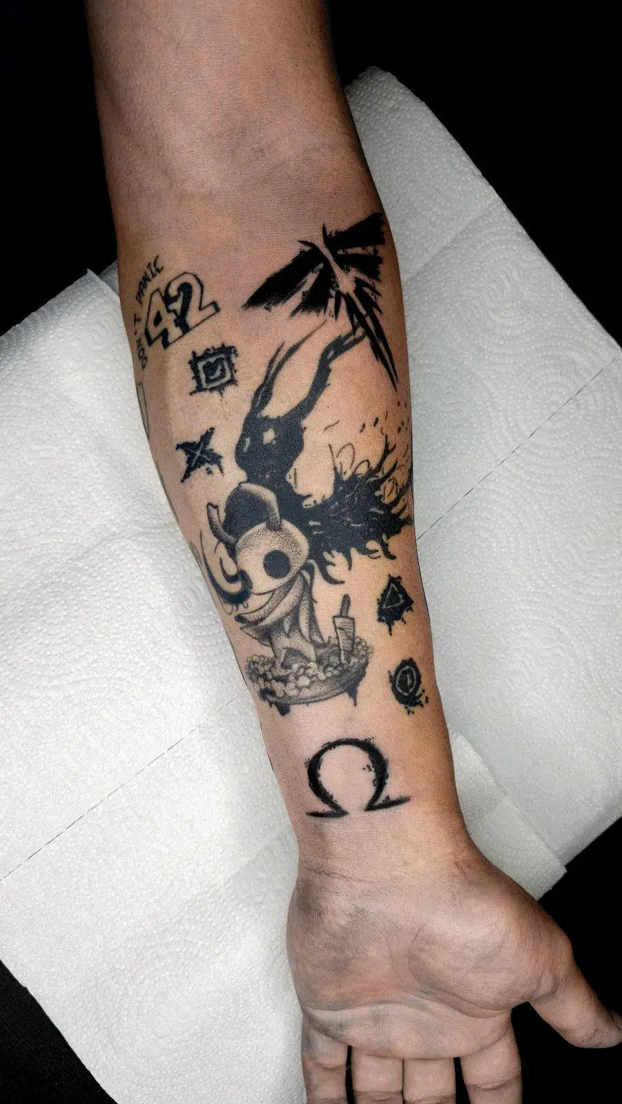 Tatuagem geek com várias referências pequenas em blackwork espalhadas pelo antebraço